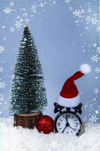 钟在圣诞老人孵化的树和球在雪中。 新年或圣诞节的装饰。