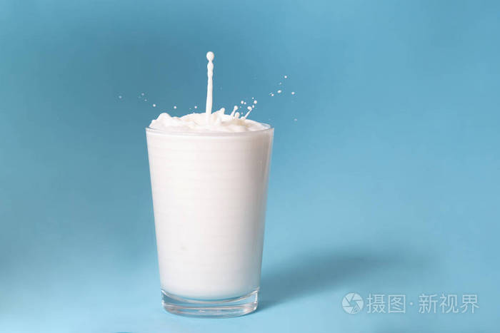 全杯牛奶隔离在蓝色背景上.