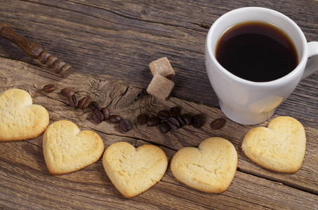 自制的心形短饼干和旧木制背景上的一杯咖啡