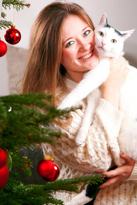 幸福的女人在客厅的家里装饰一棵圣诞树