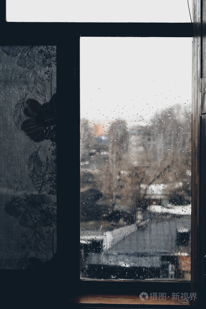 雨滴遍布玻璃和村景的背景. 初秋