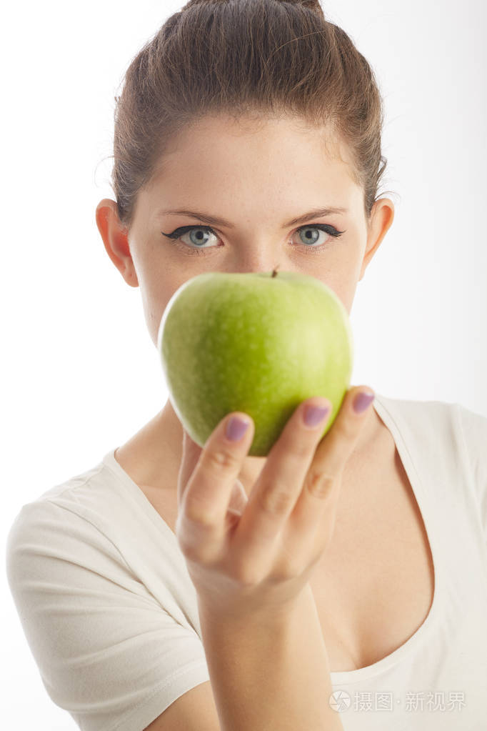 美丽的女人拿着一个绿色的苹果