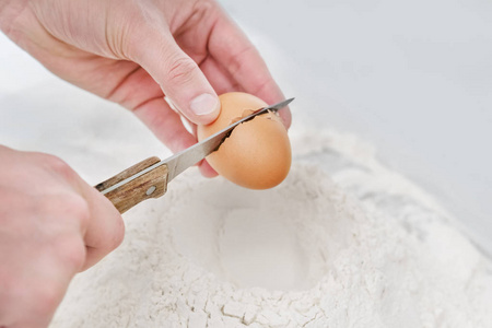 手拿刀在面粉上打碎鸡蛋