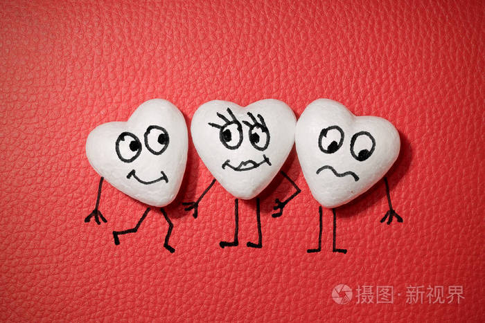 三颗白色的心红色的皮革背景上有快乐和悲伤的脸