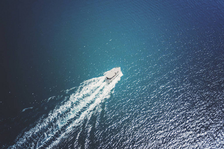 在蓝色大海中航行的白色小船的俯视图