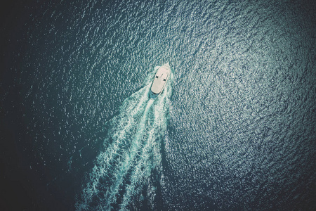 大海俯视图在蓝色大海中航行的白色小船的俯视图照片