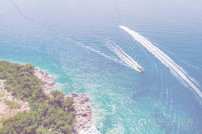 在阳光下漂浮在蓝色海面上的船的俯视图