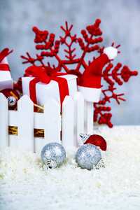 圣诞礼物和装饰品放在雪地上的白色盒子里，背景是肮脏的。 圣诞义卖。