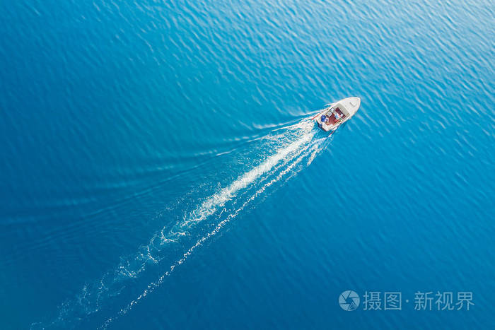 在碧海中航行的白船的俯视图