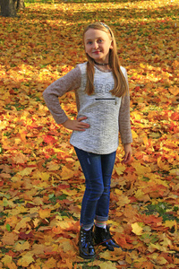 年轻的女孩体贴地站在秋天的公园里，落叶。 秋天公园里的女孩。 秋天的天气。 女孩在秋日公园休息。 黄叶盖