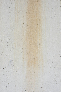 白色水泥墙背景，有水斑和多孔纹理