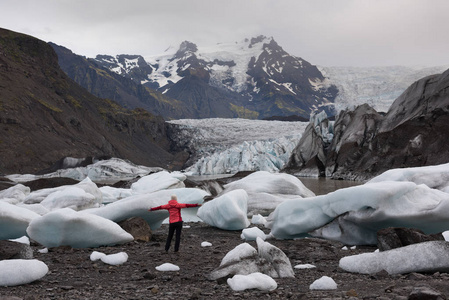 冰岛冰川自然的冒险女人。 游客附近的冰川泻湖湖泊的FjallsarlonVatna冰川vatnajokull国家公园。 年轻女