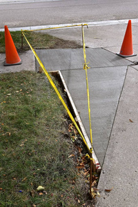 人行道修复项目被一条黄色的警示带和橙色的圆锥体包围。