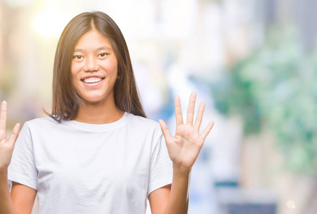 年轻的亚洲女人，在孤立的背景下，用手指8号，微笑着自信和快乐。
