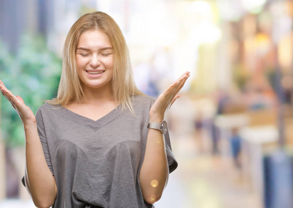 年轻的白种人女人在孤立的背景下庆祝疯狂和疯狂的成功，举起手臂和闭上眼睛尖叫兴奋。赢家概念