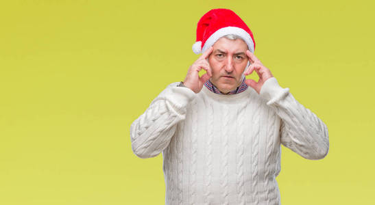 英俊的老人戴着圣诞帽在孤立的背景上，手在头上疼痛，因为压力。偏头痛。