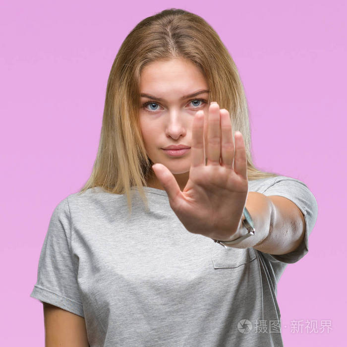 年轻的白种人女人在孤立的背景下做停止用手掌唱歌。警告表情，脸上有消极严肃的手势..