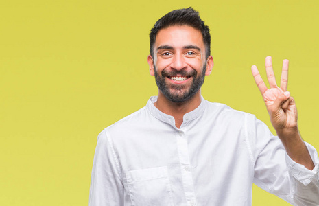 成年西班牙裔男子在孤立的背景上显示和举着手指第三，同时微笑自信和快乐。