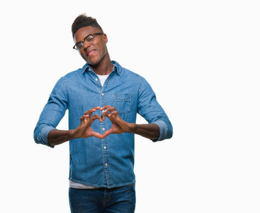 的非裔美国人,在孤独的背景下微笑,在爱中,用手显示心脏的象征和形状