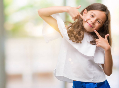 黑发西班牙女孩微笑自信,用手指牙齿和嘴巴展示和指点. 健康概念.照片