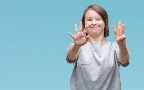 年轻的成年妇女患有唐氏综合症，在孤立的背景下，显示和举着8号手指，同时微笑，自信和快乐。