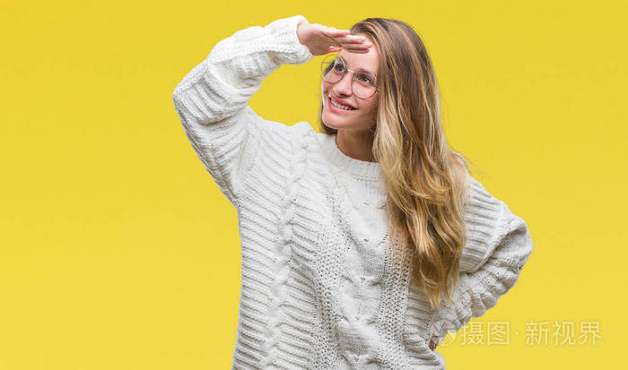 的毛衣和太阳镜,在孤立的背景上,非常高兴和微笑,用手捂住头看着远方
