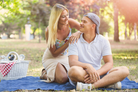 野餐时间。 年轻的微笑夫妇享受美酒，享受乐趣。 爱情与温柔约会浪漫生活理念