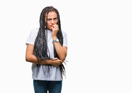 年轻的辫子非裔美国女孩在孤立的背景上看起来压力和紧张，双手咬嘴指甲。 焦虑问题。