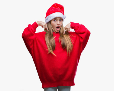 年轻漂亮的女孩戴着圣诞帽，戴着孤立的背景，自信地微笑着，用手指指着自己，骄傲和快乐。