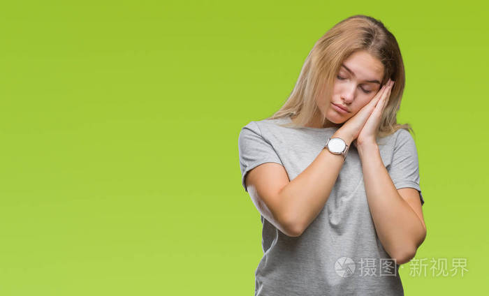 人女人在孤立的背景下睡觉,疲倦的做梦,双手一起摆姿势,闭着眼睛微笑