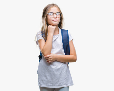 年轻漂亮的聪明学生女孩穿着背包在孤立的背景上，手在下巴上思考问题，沉思的表情。 带着体贴的脸微笑。 怀疑概念。