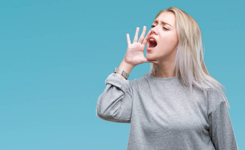 大声交流年轻的金发女人在孤立的背景上大声喊叫和尖叫,手在嘴上.