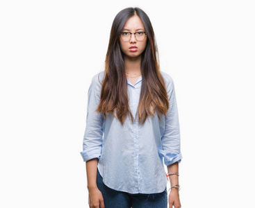 年轻的亚洲商界女性戴着眼镜，对孤立的背景持怀疑态度，紧张的眉头因问题而心烦意乱。 消极的人。