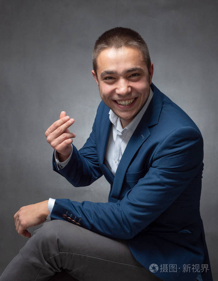 漂亮的成功商人穿着蓝色西装坐着展示表情