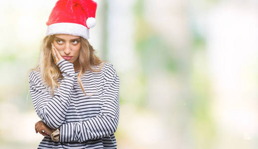 一位年轻漂亮的金发女郎，戴着圣诞帽，背景偏僻，双手交叉，看上去疲惫不堪。