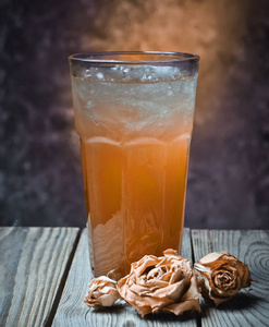 自制的酒精鸡尾酒，长着浆果汁伏特加杜松子酒，龙舌兰酒，放在一混凝土墙的背景上的木桌上。 干玫瑰。