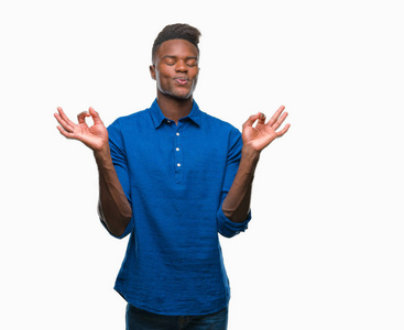 年轻的非裔美国人，在孤立的背景下放松，微笑，闭着眼睛，用手指做冥想手势。 瑜伽概念。