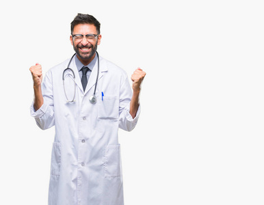 成年西班牙裔医生男子在孤立的背景下兴奋地用手臂举起庆祝胜利的微笑。 赢家概念。