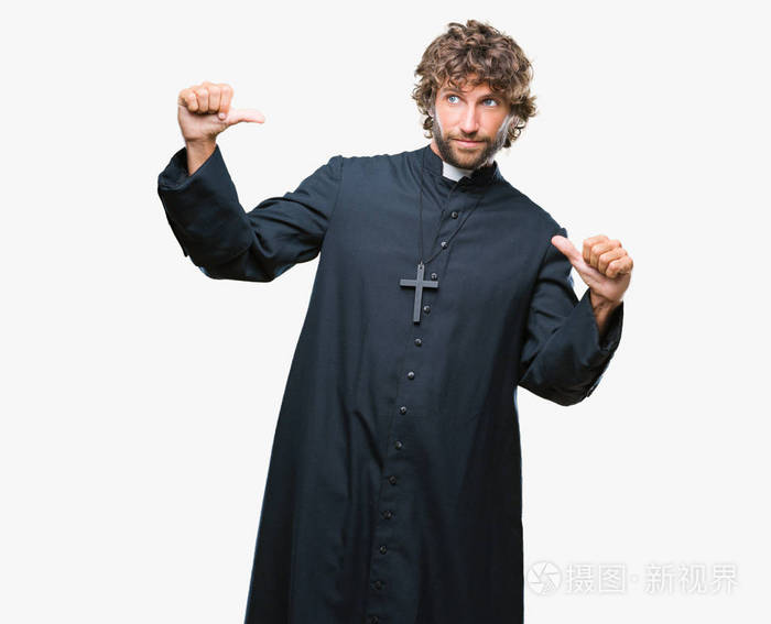 英俊的西班牙裔天主教牧师男子在孤立的背景上自信地微笑着用手指指着