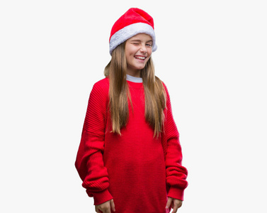 年轻漂亮的女孩戴着圣诞帽，在孤立的背景上眨眼，看着镜头，的表情，开朗和快乐的脸。