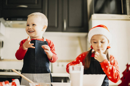 可爱的小男孩和女孩在庆祝圣诞节时准备饼干面团