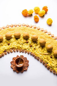 使用印度小吃糖果和迪雅或灯来庆祝迪瓦利节的兰果或设计