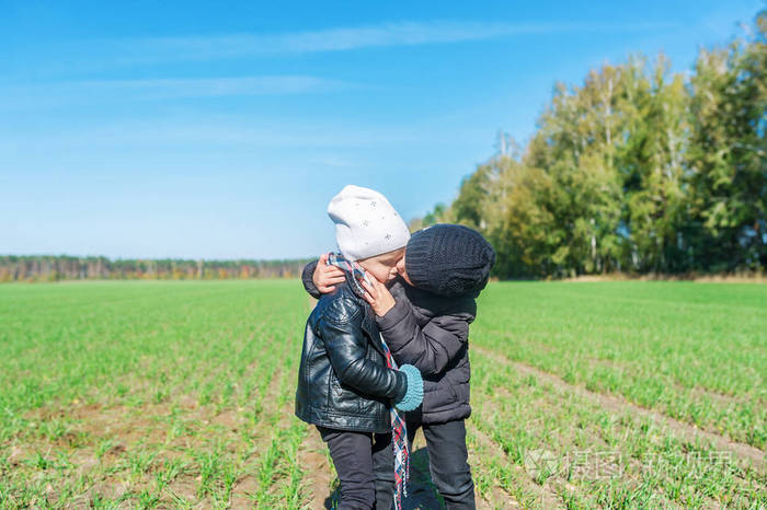 两个婴儿在户外接吻. 横向照片
