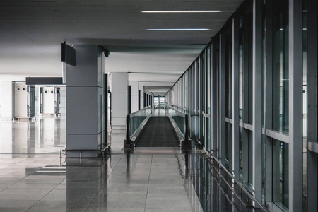 现代机场到达大厅休息室。 上海机场现代建筑的内部。 空的机场大楼。 全景窗口的明亮光线