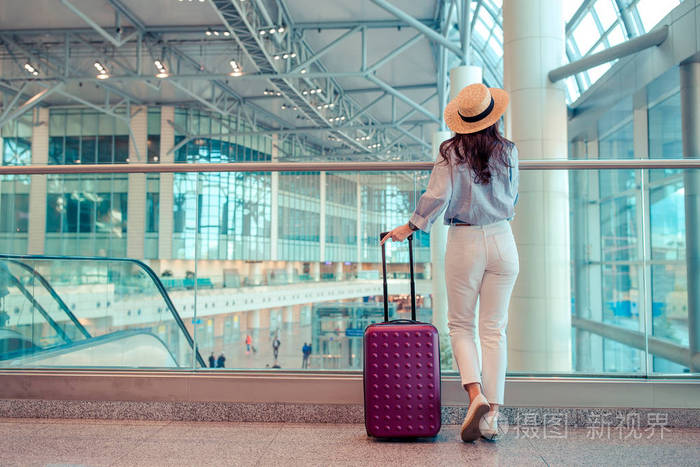 在国际机场行李帽子的年轻妇女