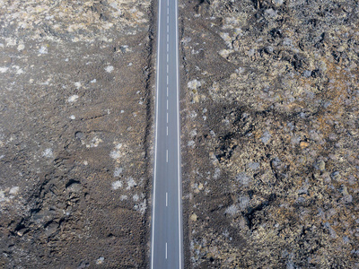 鸟瞰一条贯穿拉扎罗特加那利群岛熔岩田的道路，西班牙，非洲。 大自然