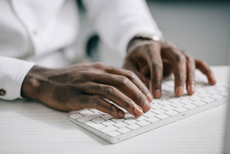 美国黑人商人在办公室电脑键盘上打字的画面