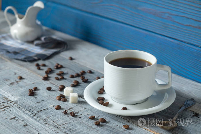 咖啡杯和蓝色木板背景上的壶