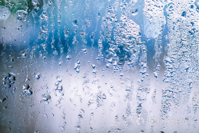 蓝色背景上有水滴的雾状玻璃