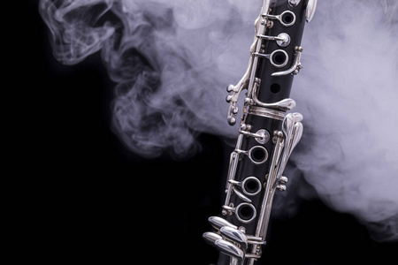黑色的单簧管，黑色背景上有镀银的烟键